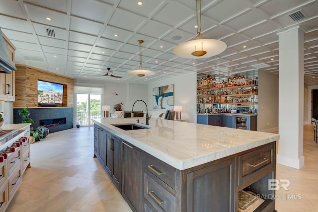27269 Perdido Beach Blvd Unit C5A, Orange Beach, AL 36561 - kitchen featuring a sink, open floor plan, a large fireplace, recessed lighting, and light stone counters