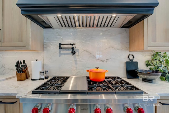 27269 Perdido Beach Blvd Unit C5A, Orange Beach, AL 36561 - kitchen with custom range hood, decorative backsplash, stove, light stone counters, and light brown cabinetry