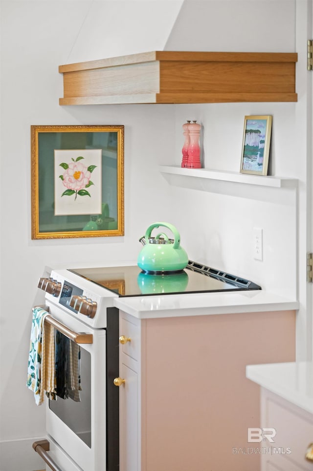 kitchen featuring open shelves, light countertops, and white range with electric stovetop