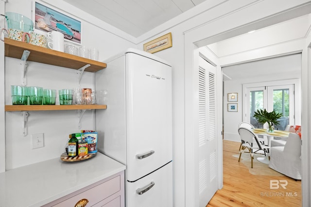 kitchen featuring light wood-style flooring, light countertops, and open shelves