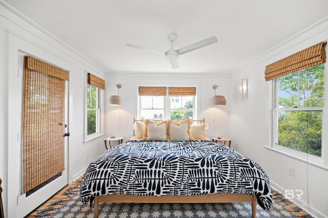 bedroom featuring ceiling fan, baseboards, crown molding, and wood finished floors