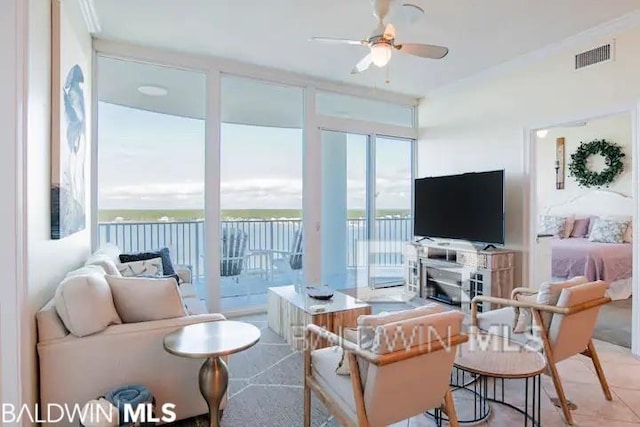 living room featuring ceiling fan and a wall of windows