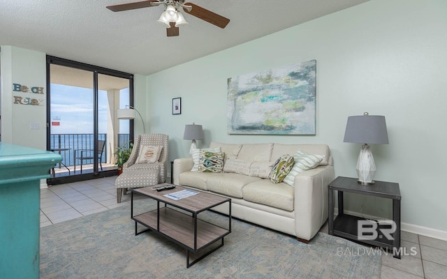 tiled living room featuring floor to ceiling windows, a textured ceiling, and ceiling fan