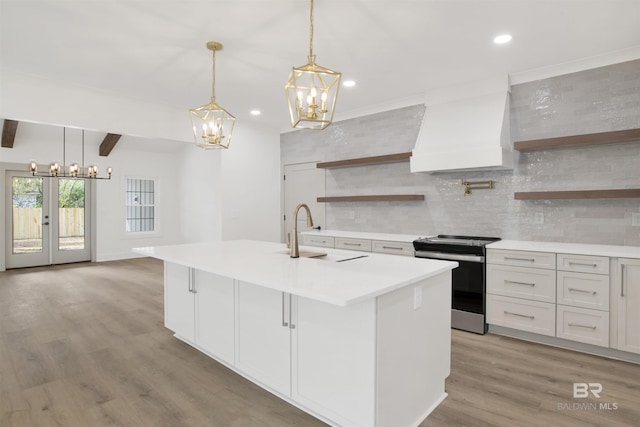 kitchen featuring custom range hood, stainless steel electric range oven, a sink, and open shelves