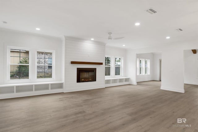 unfurnished living room featuring a fireplace, visible vents, wood finished floors, and recessed lighting