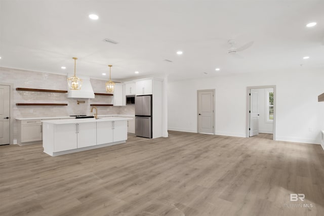 kitchen featuring freestanding refrigerator, built in microwave, light countertops, open shelves, and recessed lighting