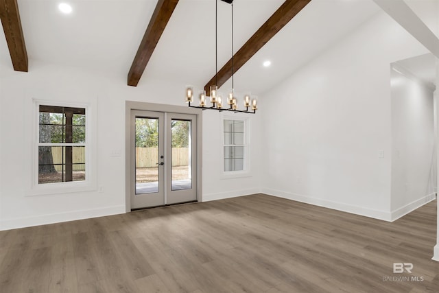 unfurnished dining area with baseboards, lofted ceiling with beams, wood finished floors, french doors, and a chandelier