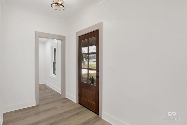 entryway with baseboards, light wood-style flooring, and crown molding