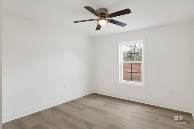 empty room with a ceiling fan, baseboards, and wood finished floors