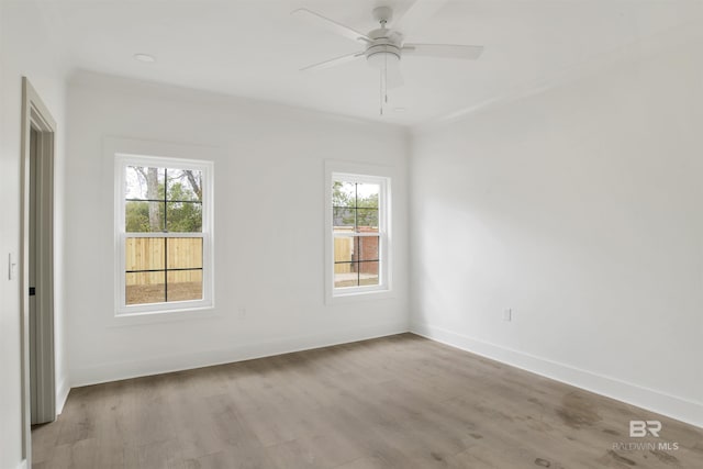 empty room with a ceiling fan, light wood-style flooring, and baseboards