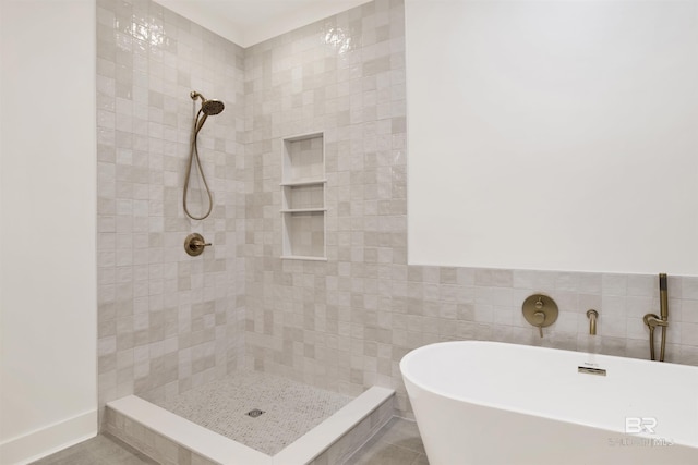 full bath with tile patterned flooring, a tile shower, and a freestanding bath