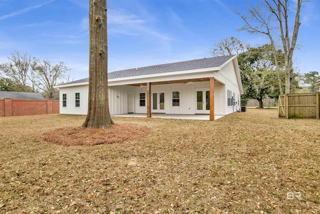 back of property with a yard, fence, a patio, and french doors