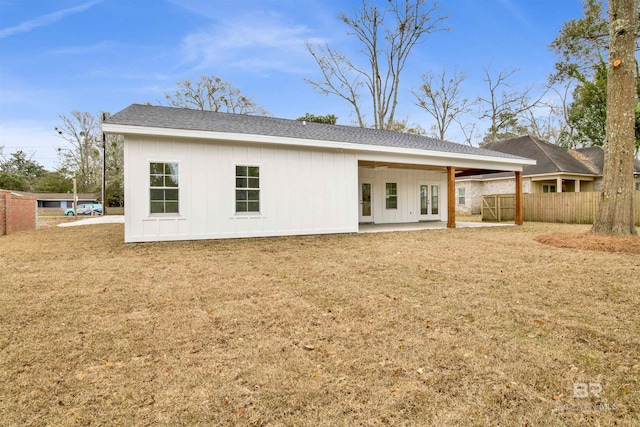 back of property featuring a lawn, fence, french doors, a patio area, and board and batten siding