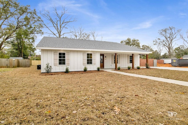 view of front facade featuring a porch, board and batten siding, a shingled roof, and fence