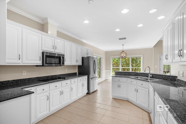 kitchen with an inviting chandelier, pendant lighting, appliances with stainless steel finishes, sink, and white cabinets