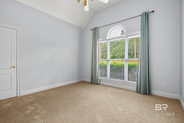 empty room with lofted ceiling, ceiling fan, and carpet