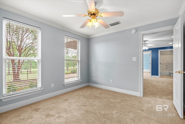 spare room with a wealth of natural light, ceiling fan, ornamental molding, and light carpet