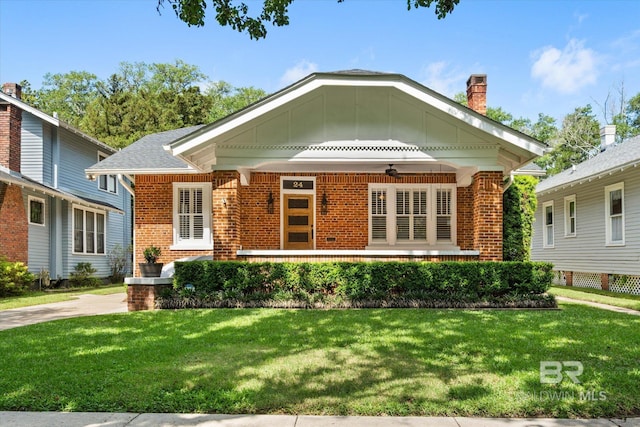 24 Macy Pl, Mobile, AL 36604 - view of front of property with brick siding, a ceiling fan, a front lawn, and a chimney