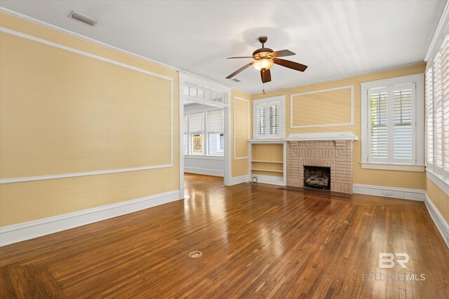 24 Macy Pl, Mobile, AL 36604 - unfurnished living room featuring ornamental molding, ceiling fan, baseboards, a fireplace, and wood finished floors