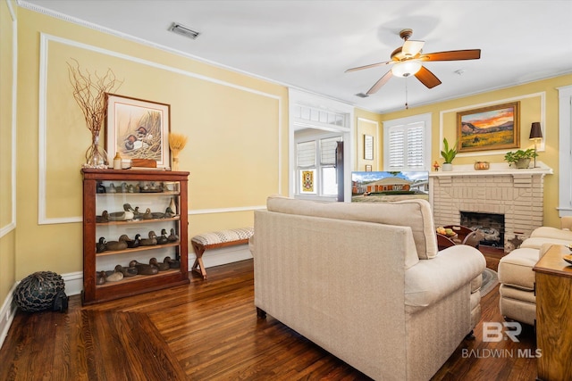 24 Macy Pl, Mobile, AL 36604 - living area featuring a ceiling fan, a brick fireplace, ornamental molding, baseboards, and dark wood-style floors