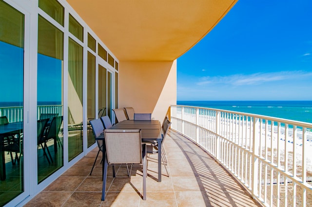 balcony featuring a view of the beach and a water view