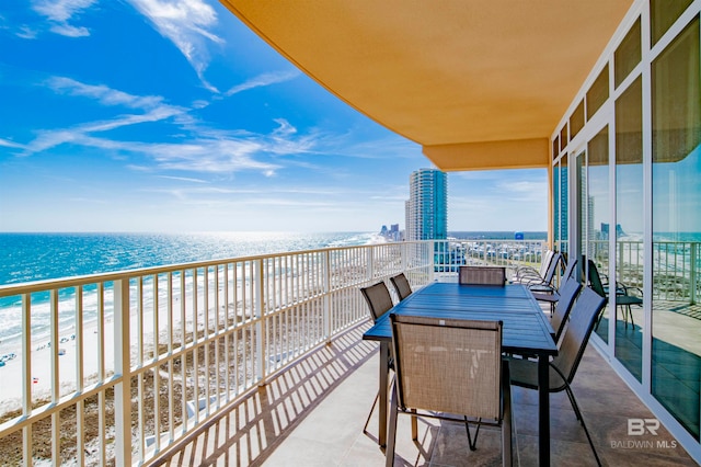 balcony featuring a view of the beach and a water view