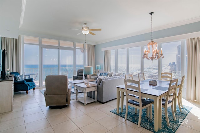 dining area with ornamental molding, ceiling fan with notable chandelier, light tile patterned floors, and a water view