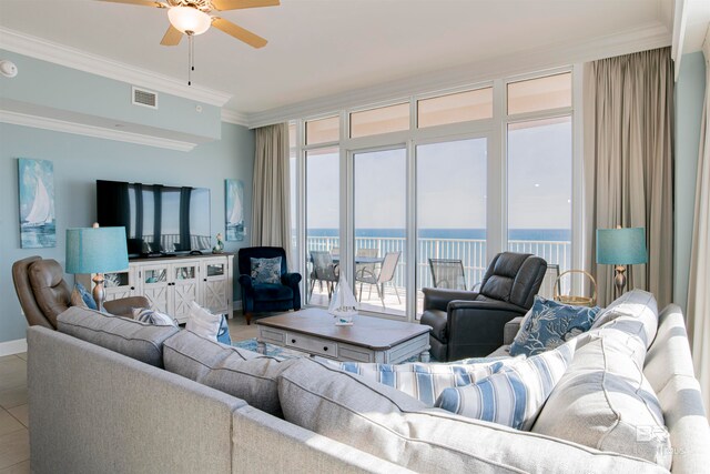 tiled living room with ceiling fan and crown molding