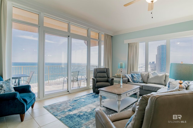 tiled living room featuring a water view, ornamental molding, and ceiling fan