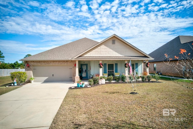 view of front of property featuring a garage, a front yard, and covered porch