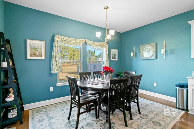 dining area with hardwood / wood-style flooring and a chandelier