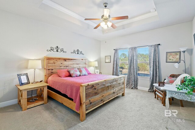 bedroom featuring carpet floors, ornamental molding, a raised ceiling, and ceiling fan