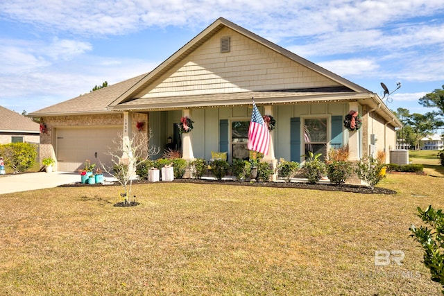 view of front facade with a porch, a garage, central AC unit, and a front yard