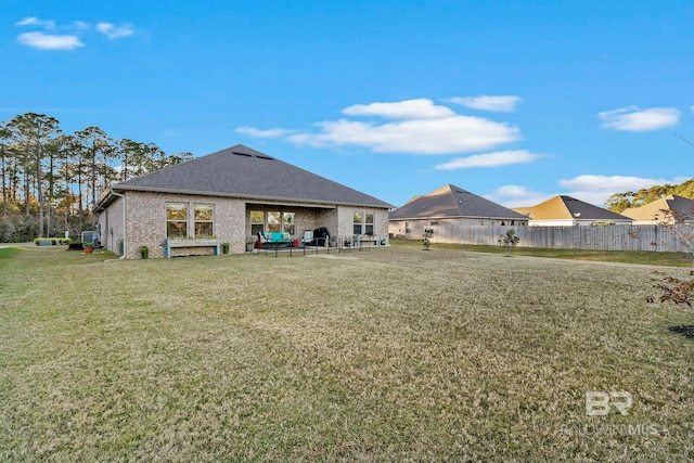 back of property with a yard and a patio