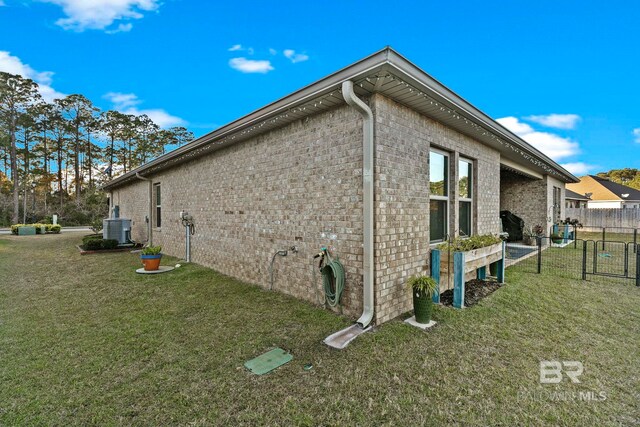 view of side of property with a yard and central air condition unit