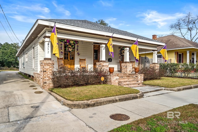 view of front of home with covered porch and a front yard