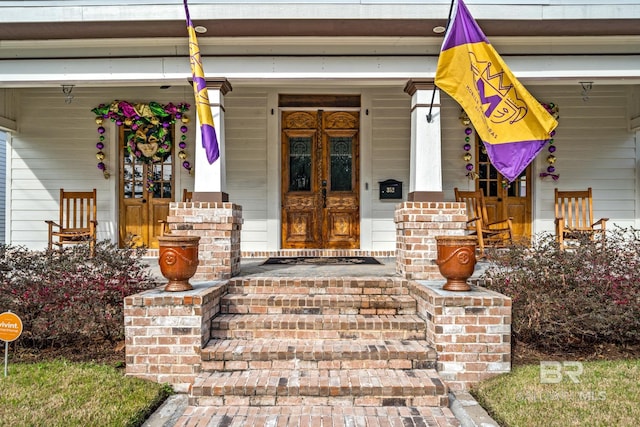 view of exterior entry featuring covered porch