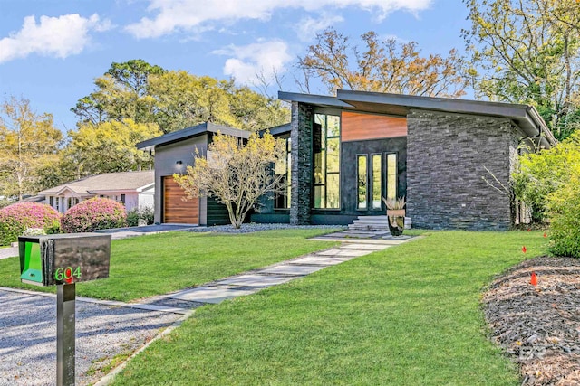 contemporary home with a front yard and a garage