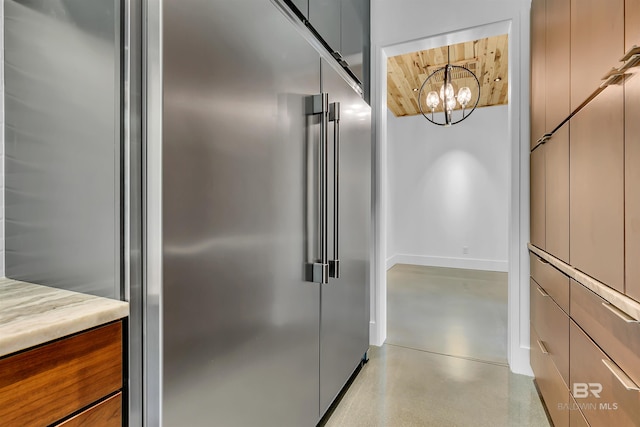 interior space with a chandelier and stainless steel built in refrigerator