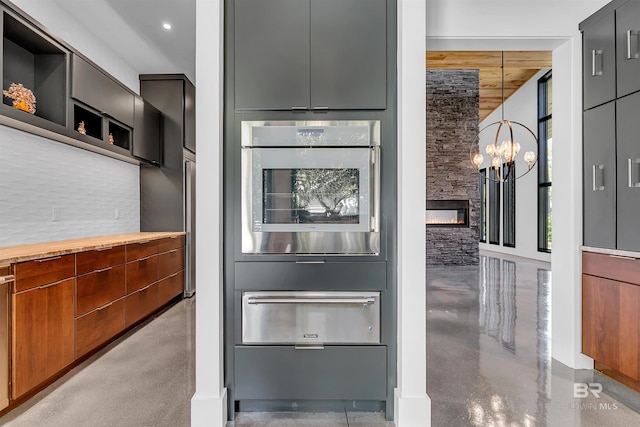 kitchen with a chandelier, pendant lighting, and a fireplace