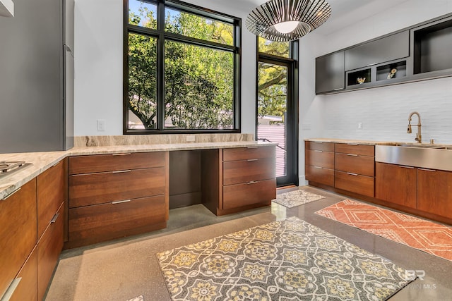 kitchen with sink, light stone counters, and plenty of natural light