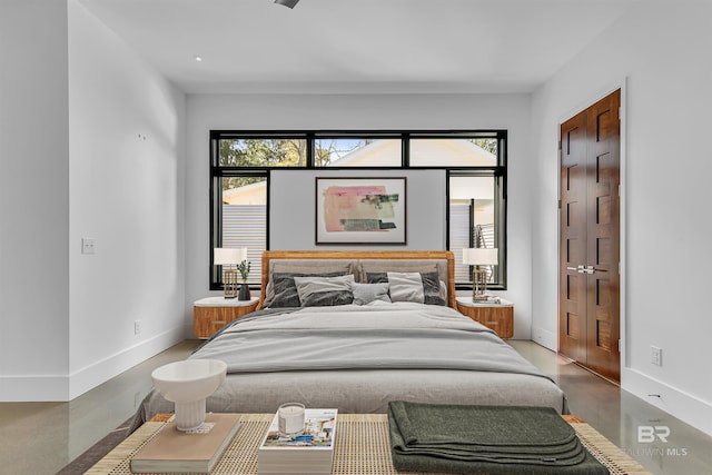 bedroom with concrete flooring and a closet