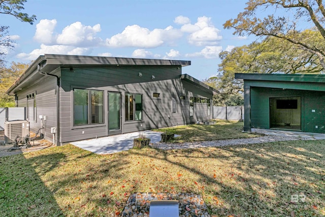 back of house with central AC unit, a yard, and a patio area