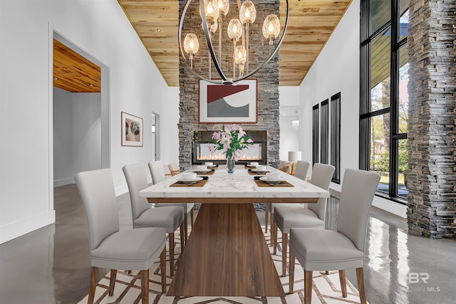 dining area with a notable chandelier, high vaulted ceiling, wooden ceiling, and a fireplace