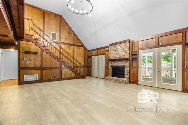 6505 Charing Wood Dr, Mobile, AL 36695 - unfurnished living room with stairs, high vaulted ceiling, wooden walls, french doors, and a chandelier