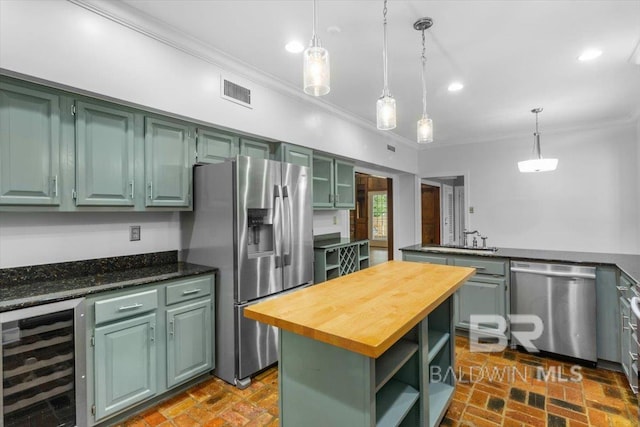 6505 Charing Wood Dr, Mobile, AL 36695 - kitchen with stainless steel appliances, beverage cooler, crown molding, brick floors, and butcher block counters