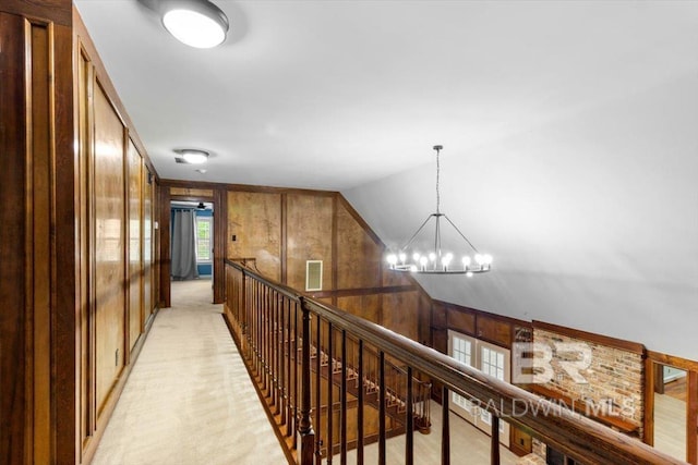 6505 Charing Wood Dr, Mobile, AL 36695 - hall with an upstairs landing, wood walls, a chandelier, vaulted ceiling, and light carpet