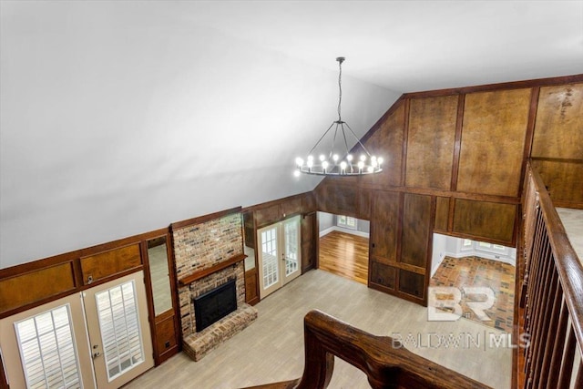 6505 Charing Wood Dr, Mobile, AL 36695 - staircase with a chandelier, french doors, vaulted ceiling, wood finished floors, and a brick fireplace