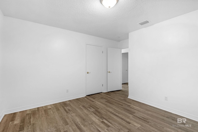 empty room featuring hardwood / wood-style floors and a textured ceiling