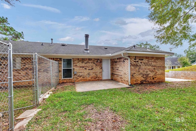 rear view of property with a yard and a patio